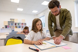 teacher helping young girl